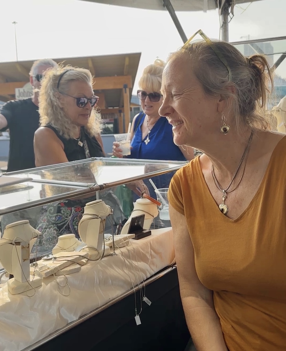 Helen Chantler, former owner of Reflective Jewelry, sits behind the counter at her booth at Milwaukee Irish Fest 2023.